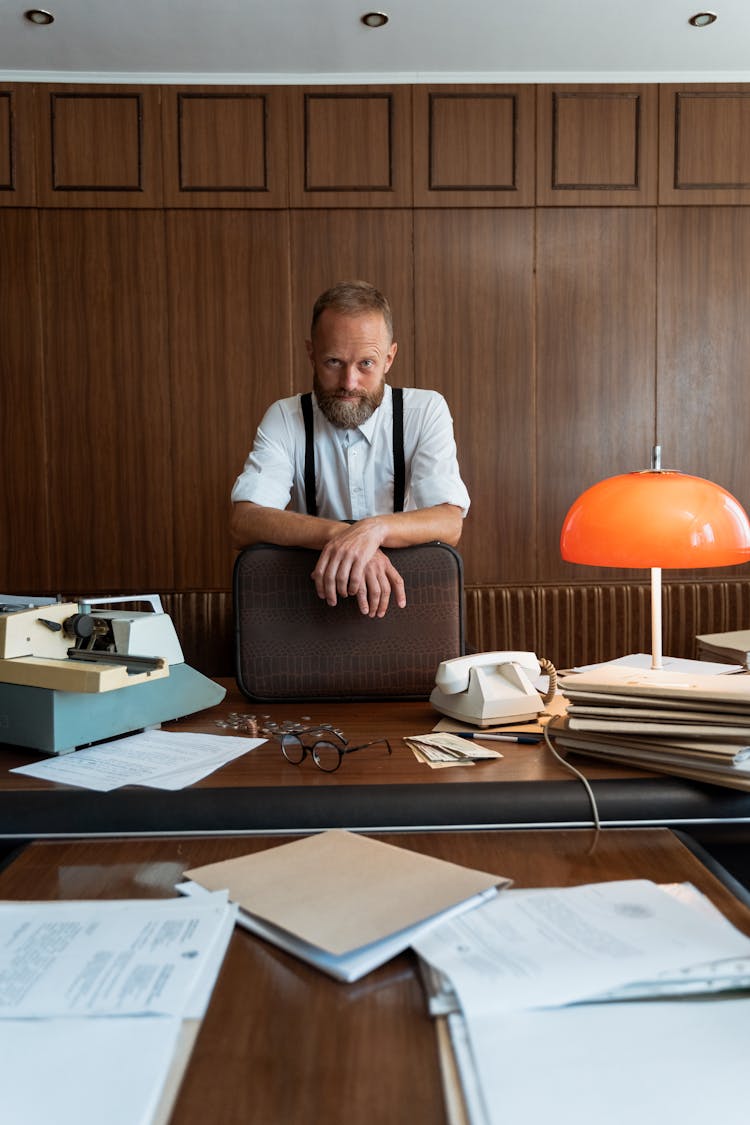 A Man In Suspenders Holding A Briefcase