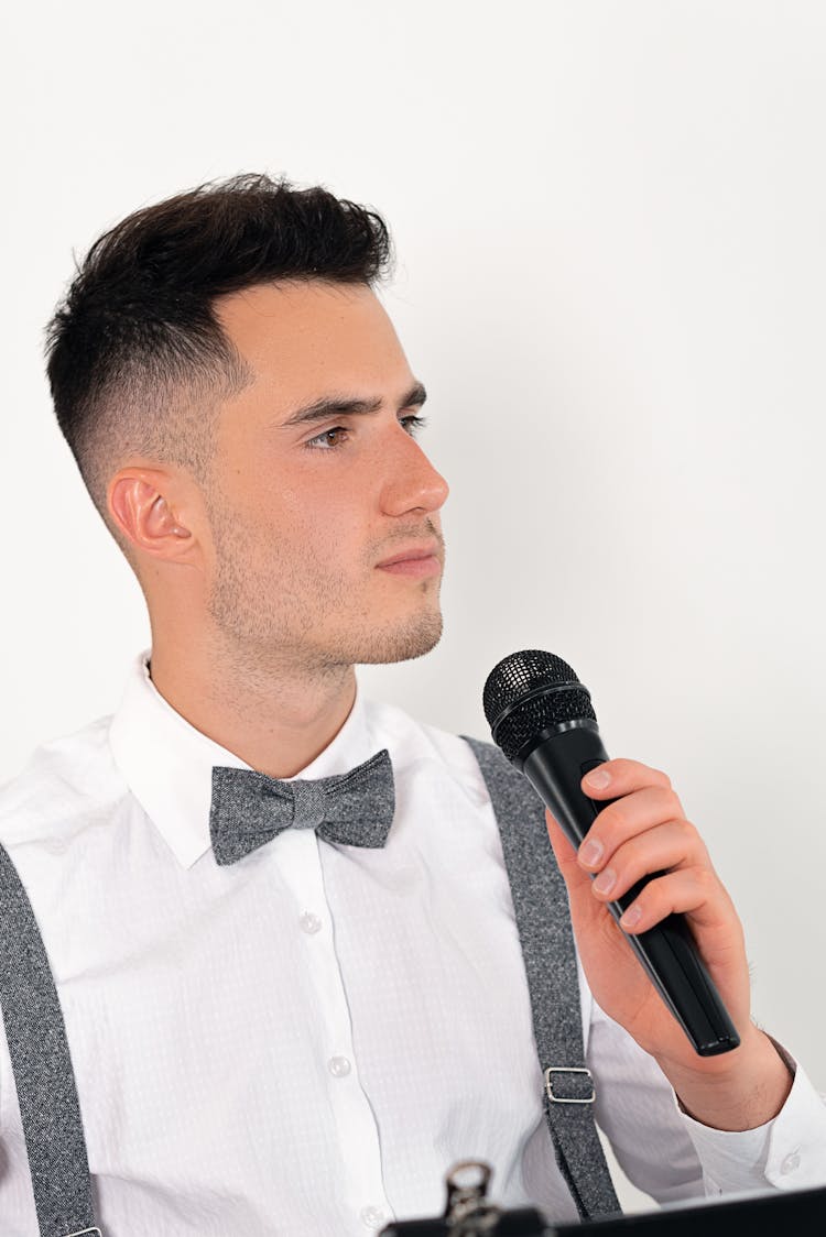 Close-Up Shot Of A Man Holding A Microphone On White Background