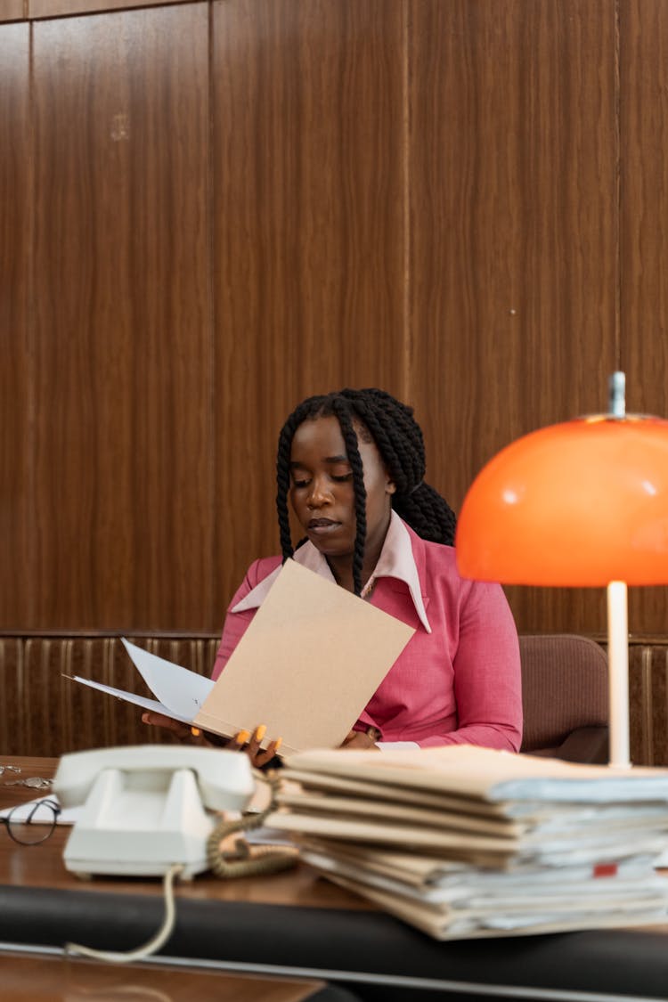 A Woman Reading Documents On A Folder