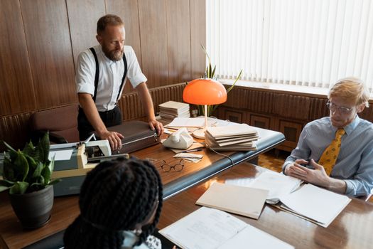 Business meeting in a vintage-styled office with retro decor and classic attire.