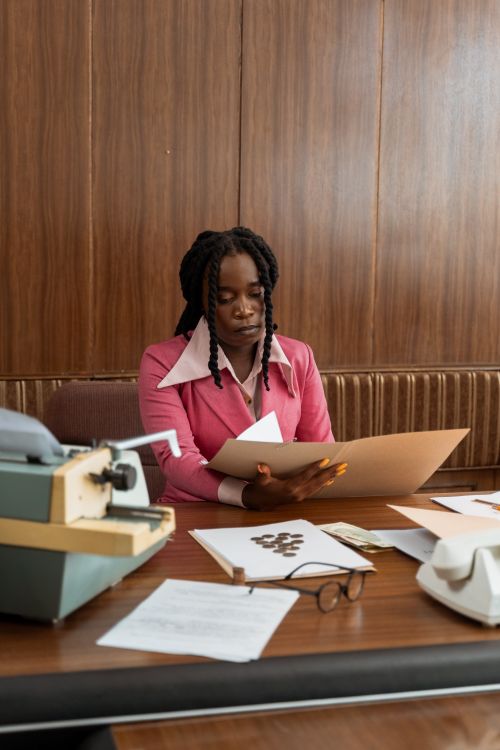 Free Retro 80s office scene with businesswoman working at desk with typewriter and vintage phone. Stock Photo