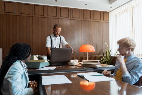 Free A classic office meeting scene with vintage elements, featuring diverse professionals. Stock Photo