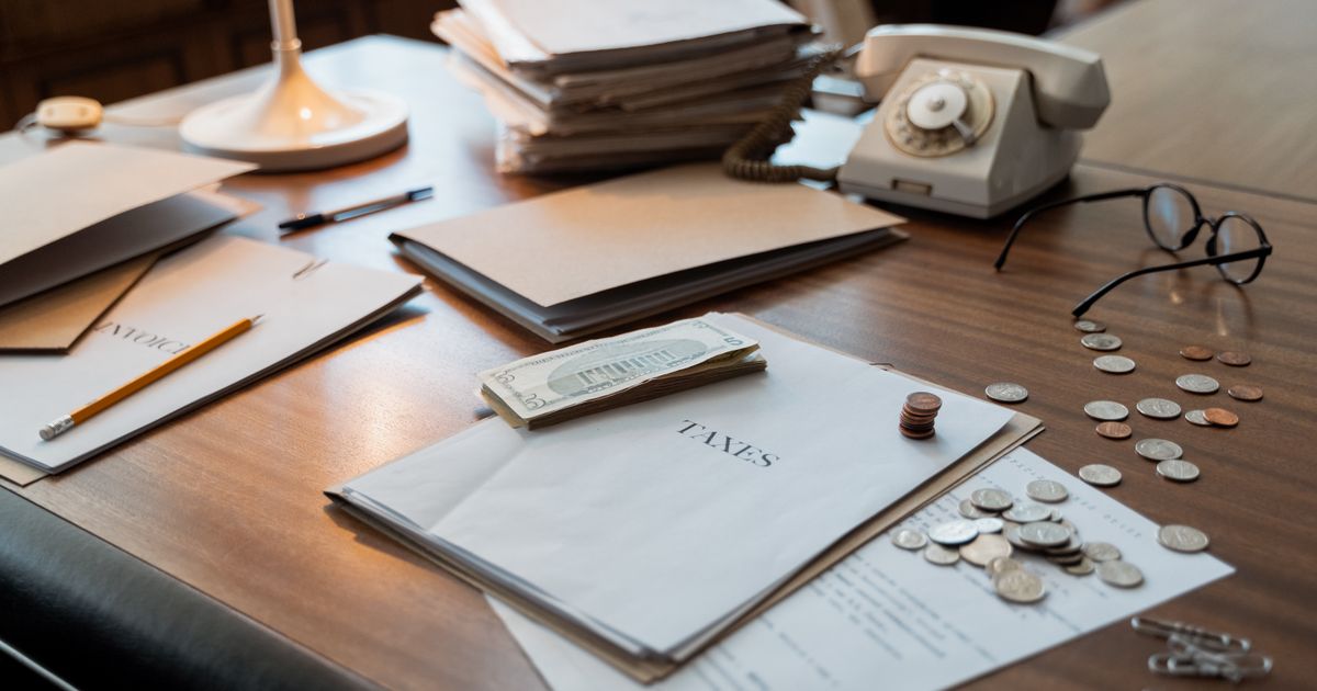 Vintage desk with folders labelled Taxes, coins, and a rotary phone