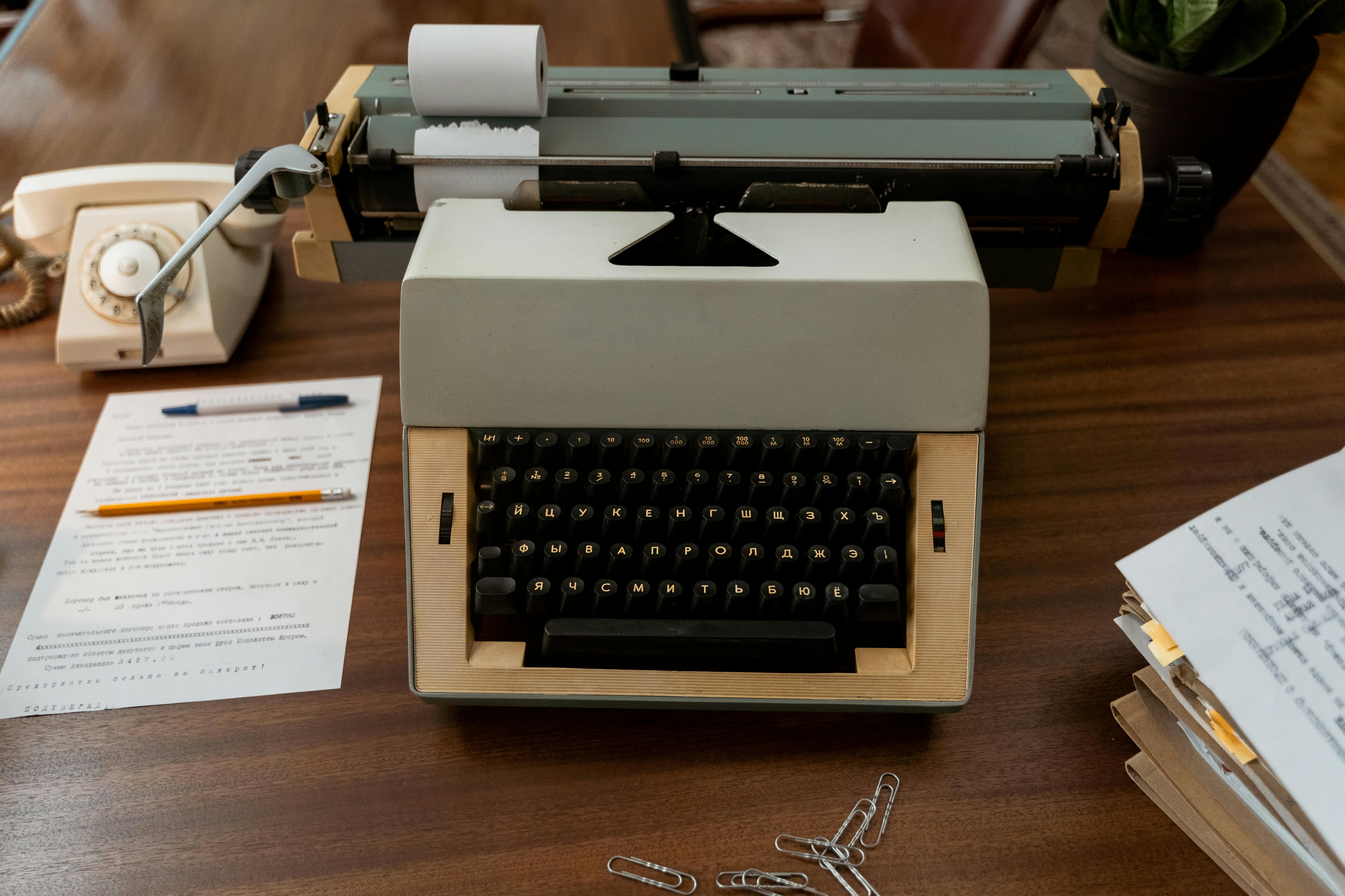 white and black typewriter on brown wooden table