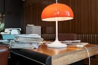 A Lamp beside a Stack of Documents on a Wooden Desk