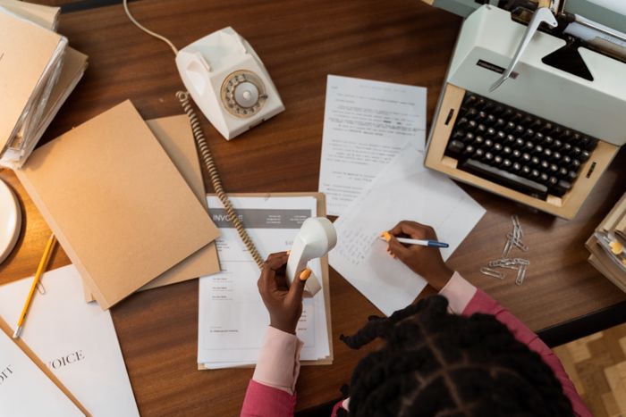 Attachment: printed invoice pages on a desk, photo by MART PRODUCTION on Pexels