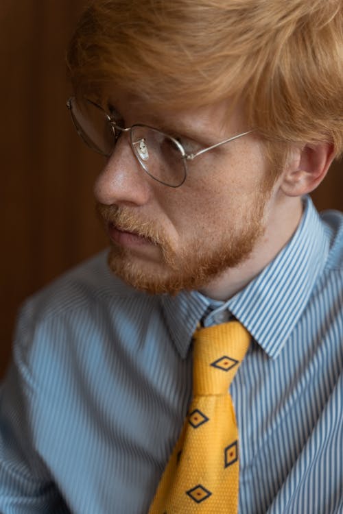 A Bearded Man in Striped Shirt and Yellow Necktie