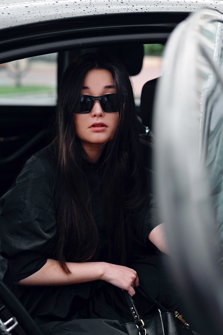 Woman With Sunglasses Getting Out Of A Car