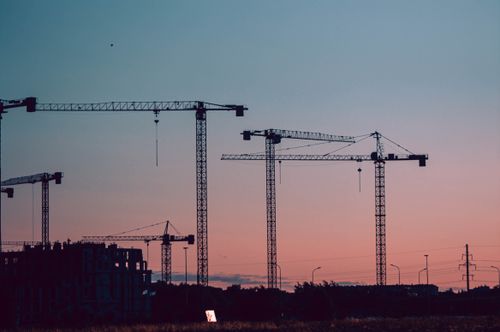 Free Silhouettes of construction cranes set against a colorful sunset sky in Kaliningrad, Russia. Stock Photo