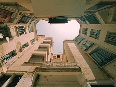 Low-angle view of rustic urban alleyway surrounded by tall buildings