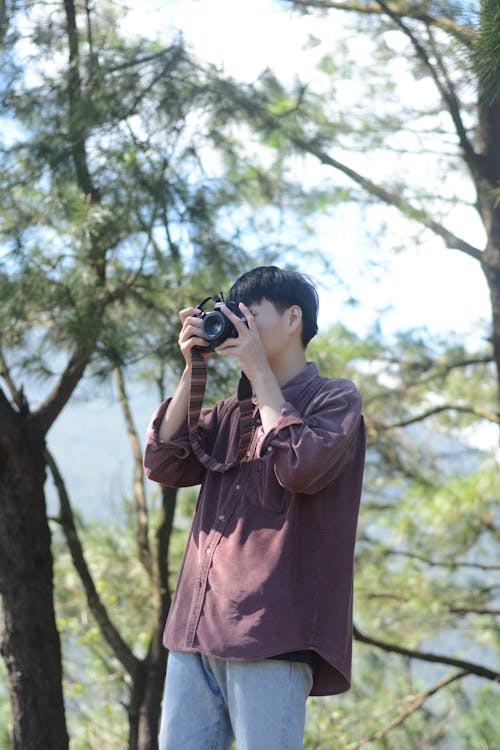 Man in Brown Long Sleeve Shirt Holding Black Dslr Camera