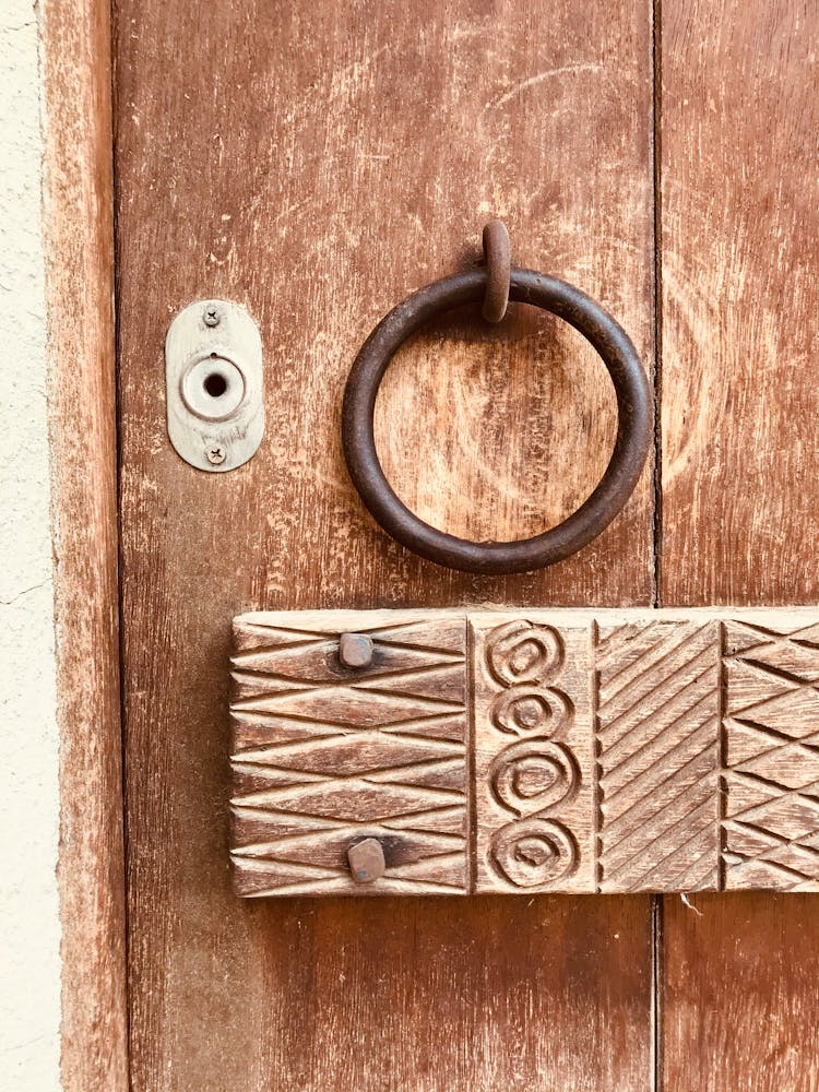 Decorated Woden Panel And Brass Door Knocker On A Old Door 