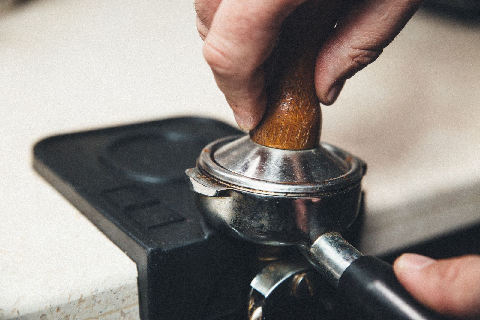 Barista pressing a manual tamper into a portafilter