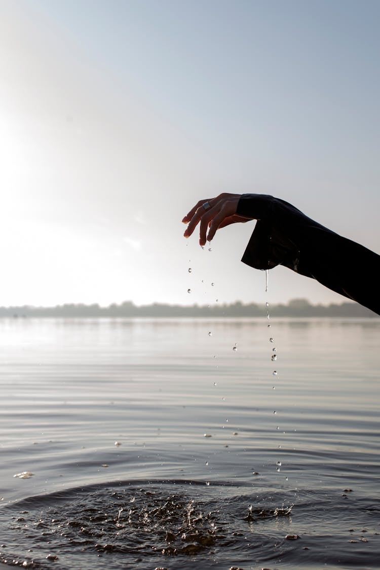 Water Droplets Falling From A Hand