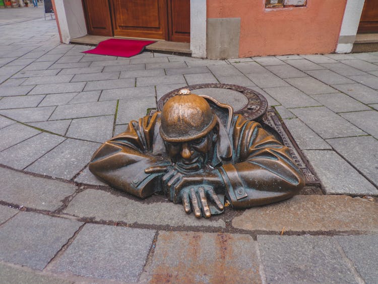 The Brass Statue Of Cumil The Sewer Worker In Bratislava, Slovakia