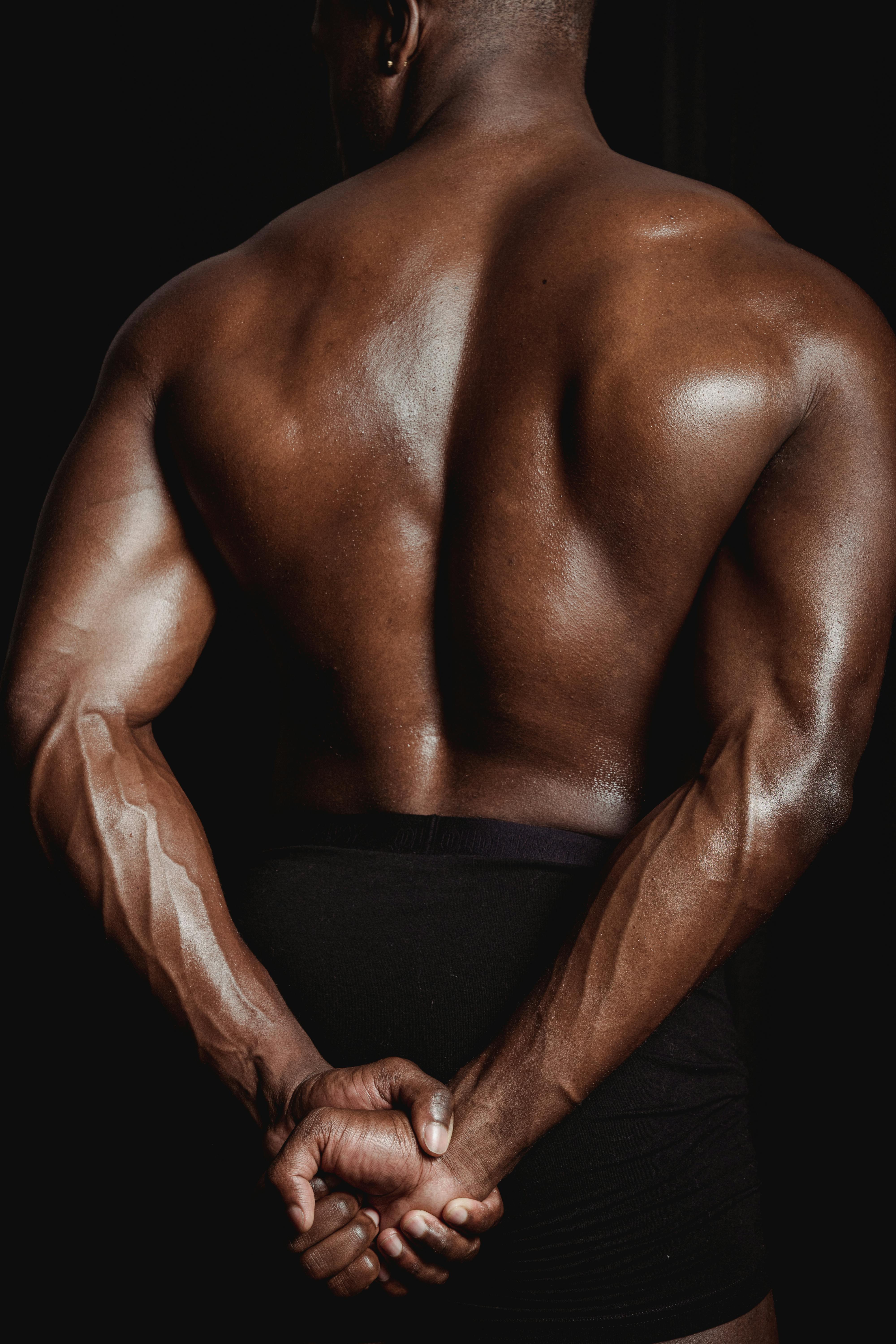 Muscular Man Flexing Back Muscles Pose Stock Photo