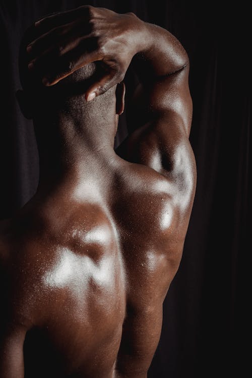 Back View of a Topless Man with His Hand on His Head