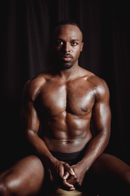 Free Strong and muscular man sitting shirtless, showcasing fitness and masculinity in an indoor studio setting. Stock Photo