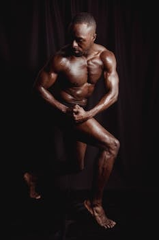 Portrait of a powerful shirtless bodybuilder flexing his muscles in a dramatic pose.