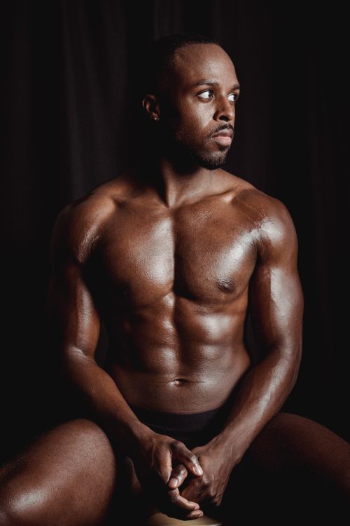 Free Muscular man posing shirtless, showcasing strong biceps and torso. Fitness and strength concept. Stock Photo