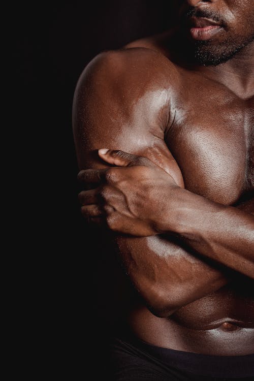 A Topless Man with His Hand on His Bicep