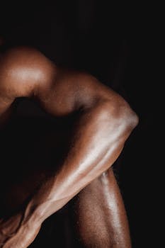 Close-up of a male bodybuilder's muscular arm showcasing strength and definition.