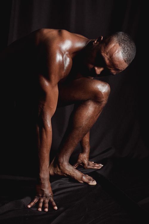 Free Dynamic studio shot of a fit, shirtless man posing gracefully. Showcasing strength and poise. Stock Photo