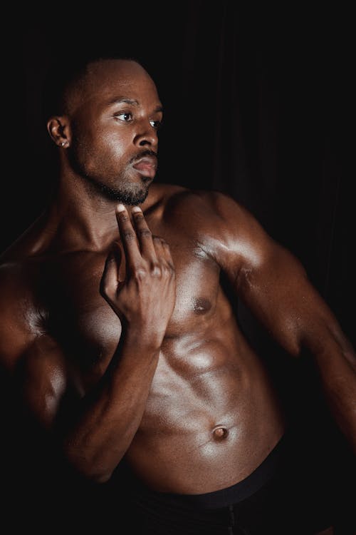 Photo of a Shirtless Man Posing with His Hand