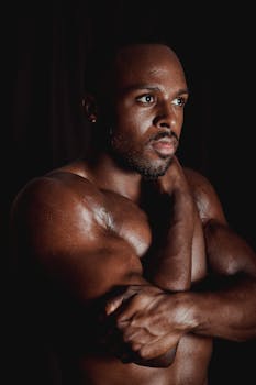 Muscular man posing shirtless, showcasing strength and determination.