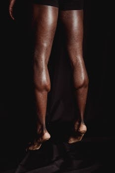 Close-up of an athlete's muscular legs from behind, highlighting fitness and strength.