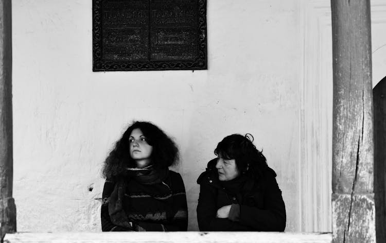 Women Talking Near Monument Sign