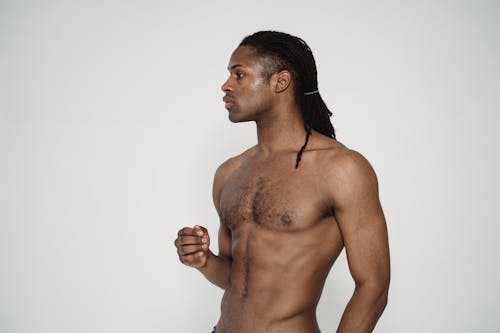Photo of a Topless Man with Dreadlocks