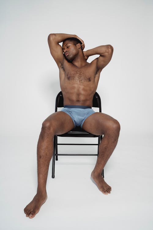 A Man Wearing Underwear Sitting on the Chair
