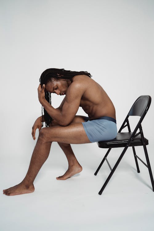 Topless Woman Sitting on Folding Chair