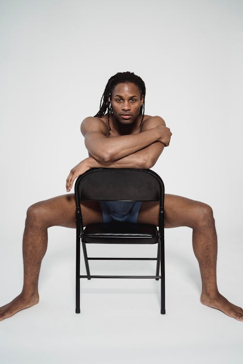 Free Topless Man Sitting on Black Chair Stock Photo