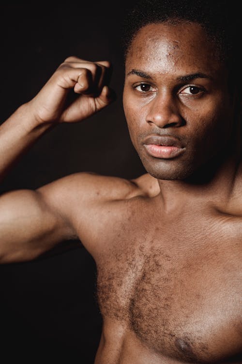 A Shirtless Man Flexing his Biceps