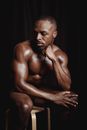 Muscular Man Sitting on Wooden Stool