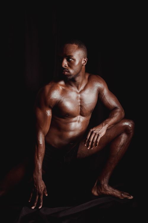 Free Dark and dynamic portrait of a muscular man posing shirtless on a black background. Stock Photo