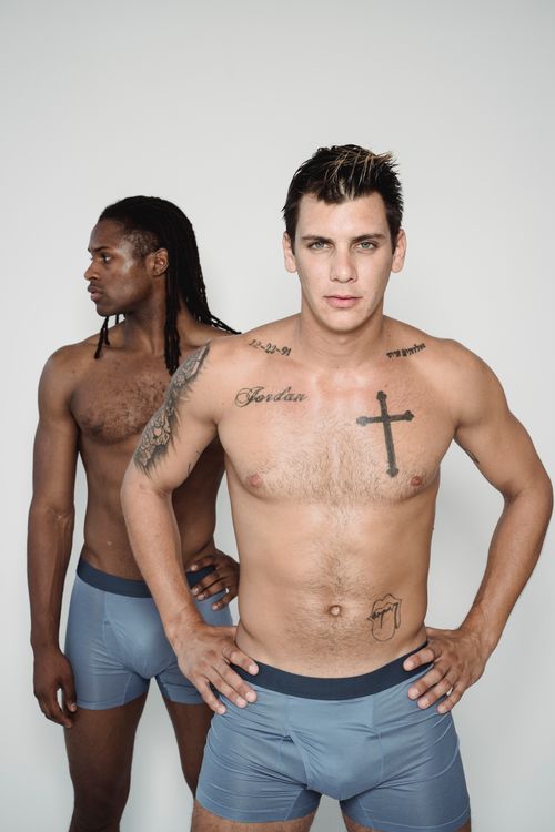 Free Two men posing confidently in a studio setting, showcasing tattoos and muscular physiques. Studio shot. Stock Photo