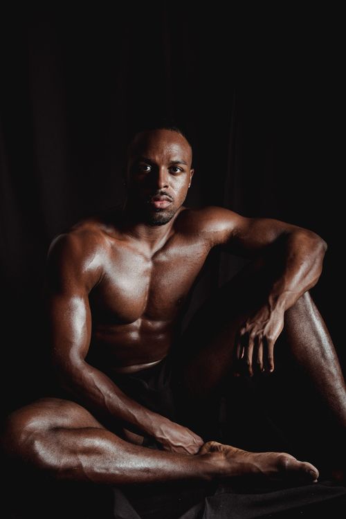 Free A powerful portrait of a shirtless man showcasing muscular physique in dim lighting. Stock Photo