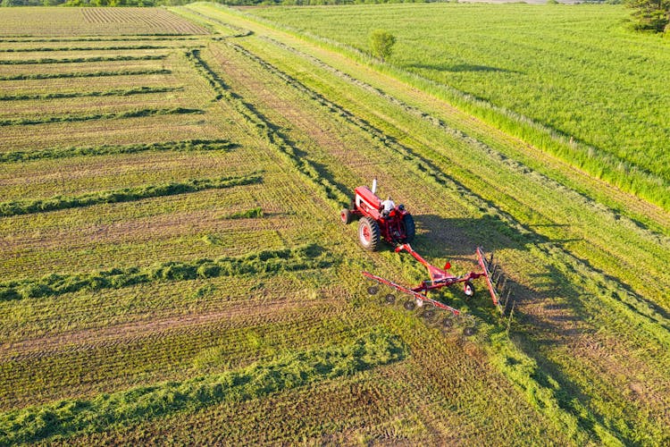 High Angle View Of A Red Tractor In A Green Field