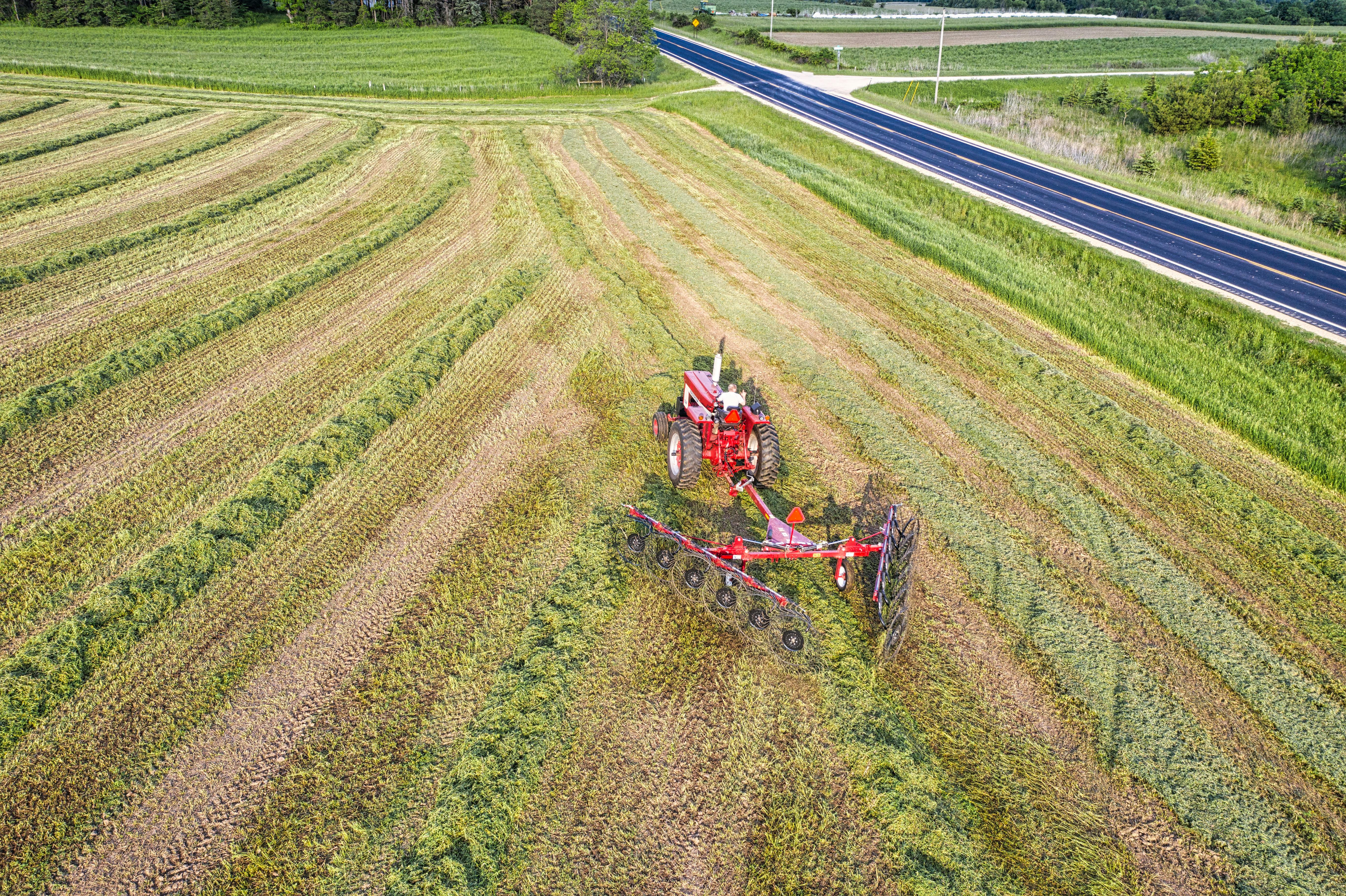 Aerial View of a Tractor with a Rake on a Field · Free Stock Photo