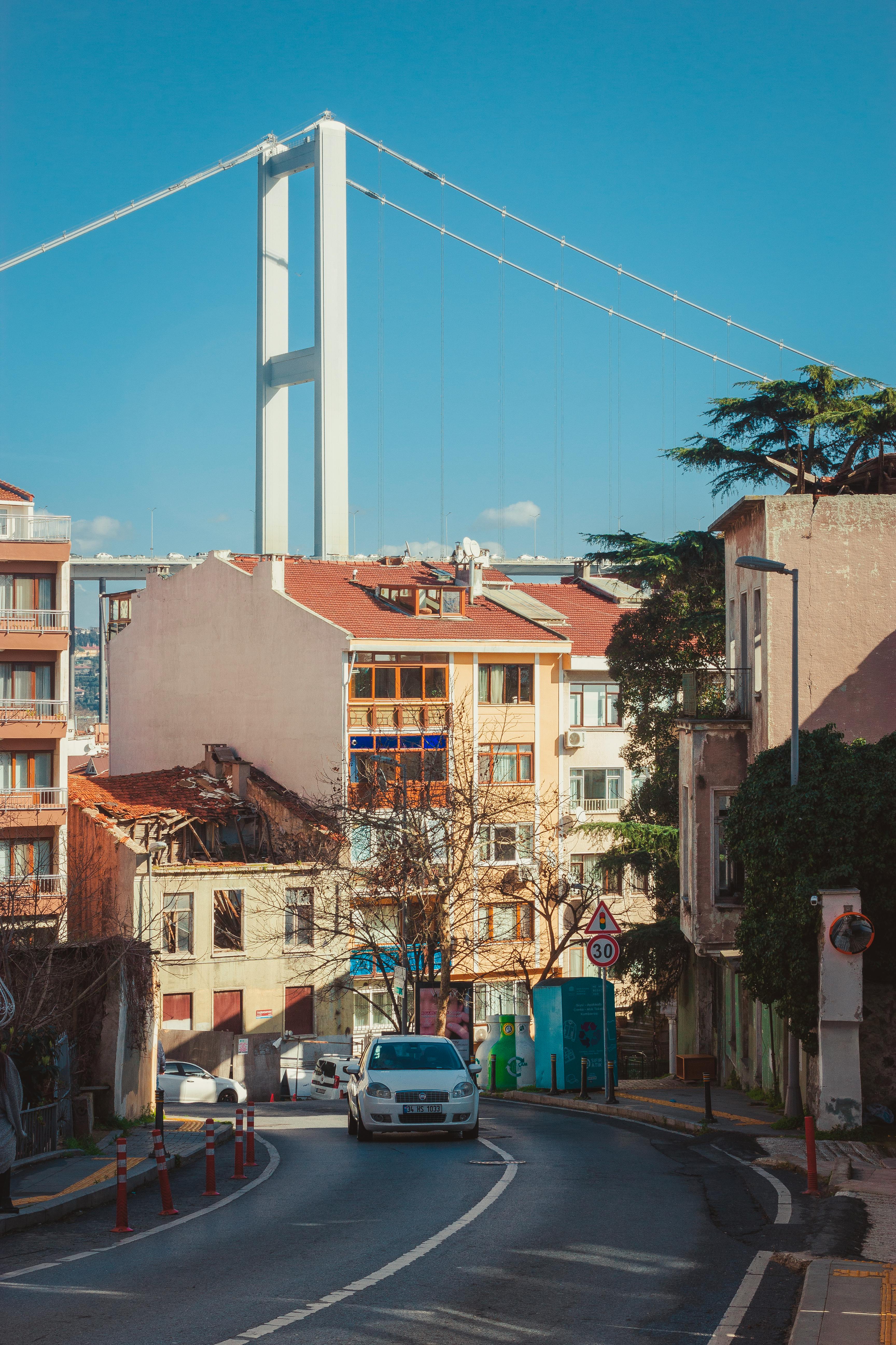 Photo of a White Car on the Road Near a Bridge · Free Stock Photo