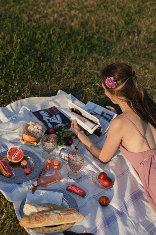 A Woman Doing Picnic While Reading Magazine