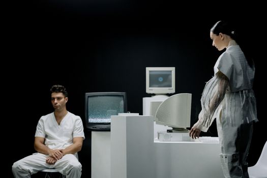 A man and woman in a futuristic lab setting with vintage monitors, evoking a sci-fi atmosphere.