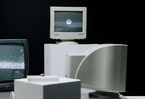 Vintage monitors displayed with static screens in a dark studio setting.