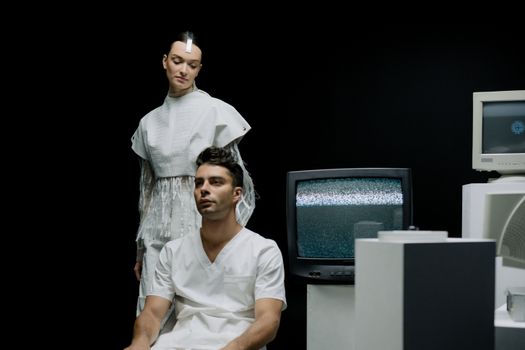 Futuristic fashion scene with a man and woman in a minimalist lab-like setting.