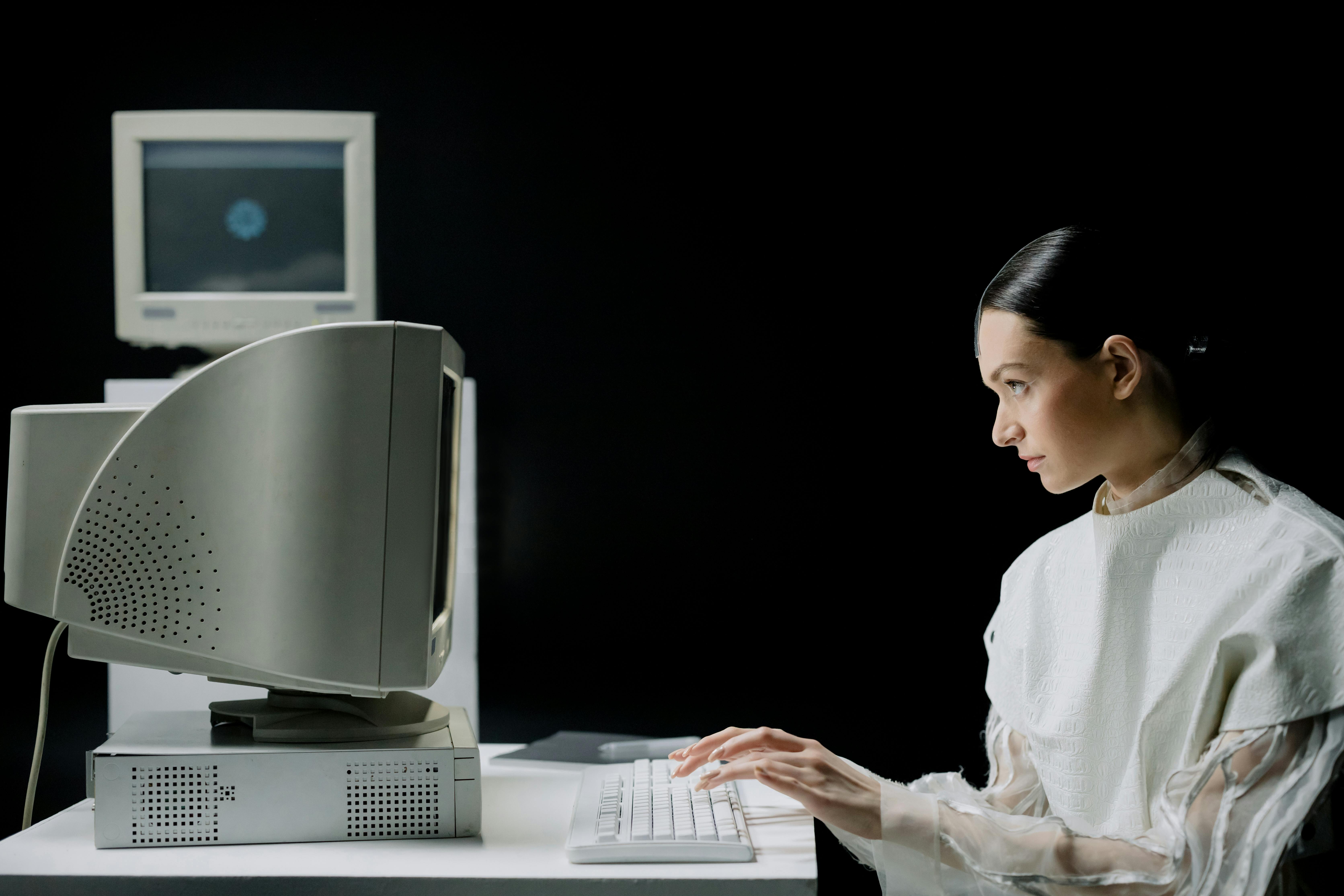 Woman in White Clothing Using a Computer