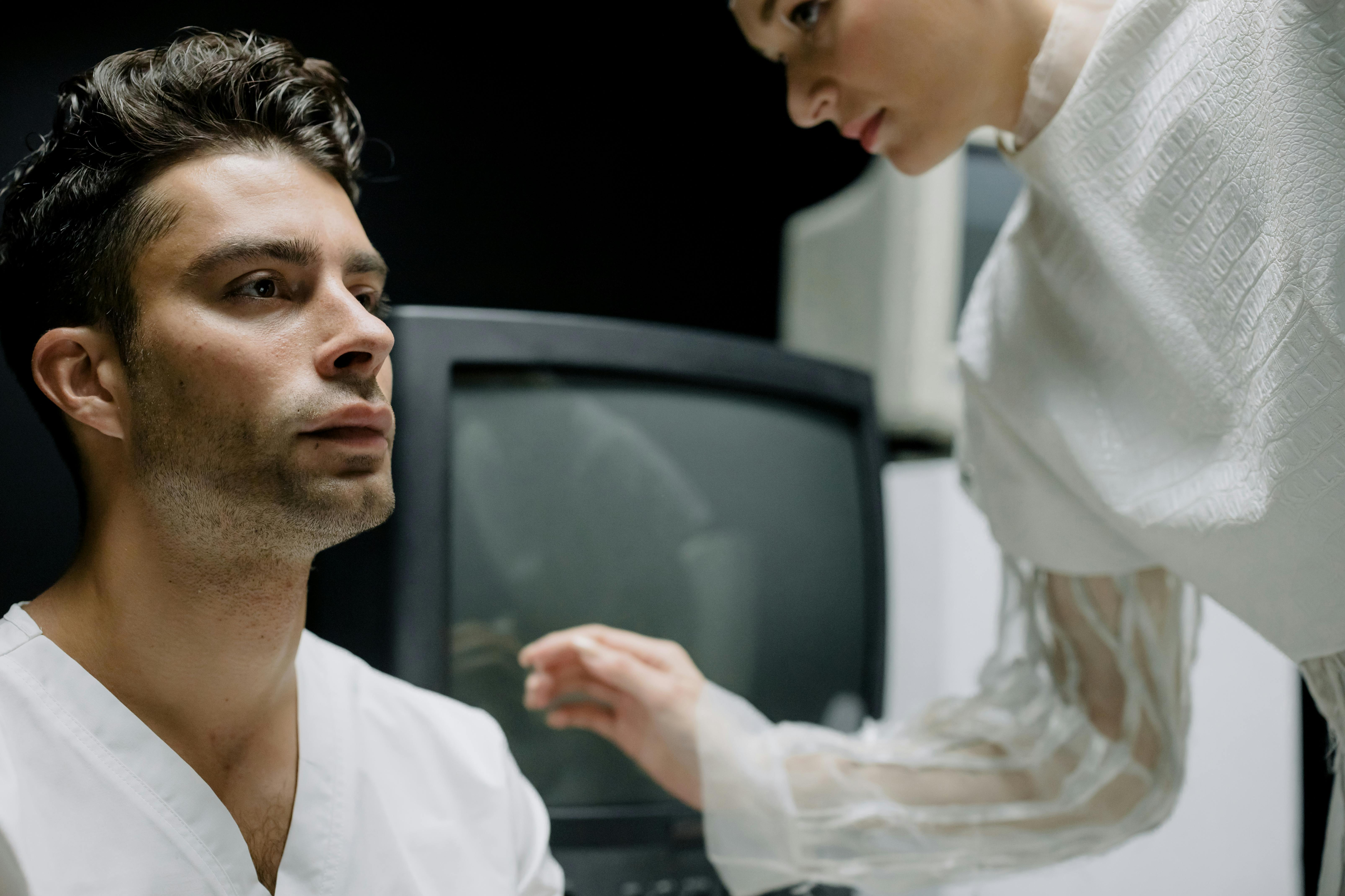 Person consulting with a healthcare professional about jaw pain, showing proper examination technique - temporomandibular joint disorder