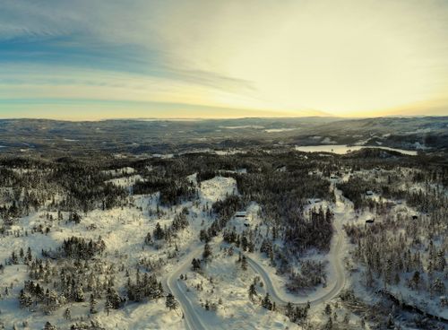 Free Breathtaking aerial winter landscape of Krødsherad, Viken, Norway, showcasing snow-covered forests and roads at sunrise. Stock Photo